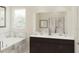 Bathroom with a soaking tub, double vanity with dark cabinets, and walk-in shower with decorative tile at 3013 Howley Aly, St Cloud, FL 34771