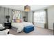 Stylish bedroom featuring a large bed, statement art, modern lighting, and a comfortable blue ottoman at 3013 Howley Aly, St Cloud, FL 34771