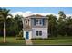 Charming two-story home featuring light gray siding, stone accents, a blue front door, and lush landscaping at 3013 Howley Aly, St Cloud, FL 34771