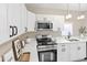 Modern kitchen with stainless steel appliances, white cabinets, and quartz countertops at 1101 Dr Martin L King Jr Way, Haines City, FL 33844