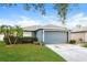 Lovely single-story home featuring manicured landscaping and a gray two-car garage at 2216 Heathwood Cir, Orlando, FL 32828