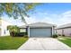 Charming single-story home featuring a manicured lawn and a two-car garage at 2216 Heathwood Cir, Orlando, FL 32828