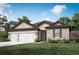 Charming single-story home featuring a three-car garage, manicured lawn, and beautiful landscaping at 2649 Sw 176Th Loop, Ocala, FL 34473