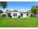 Spacious backyard with lush green lawn, sliding glass doors, mature trees, and partial fencing at 408 S Edgemon Ave, Winter Springs, FL 32708