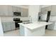 Well-equipped kitchen featuring gray cabinetry, stainless steel appliances, and a central island with a sink at 2071 Babbling Brook Blvd, Auburndale, FL 33823