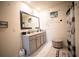 Bathroom with double sinks, granite countertop, decorative mirror, and neutral tones at 3017 Country Club Cir, Winter Haven, FL 33881