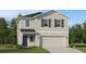 Charming two-story home featuring vertical siding, decorative shutters, attached two car garage, and manicured lawn at 3403 Howell Dr, Lake Wales, FL 33859