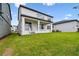 Spacious backyard featuring a covered patio, lush green lawn, and a modern two-story home at 16994 Cedar Valley Cir, Clermont, FL 34711