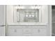 Elegant bathroom with double vanity, bright lighting, and tiled shower in the background at 16994 Cedar Valley Cir, Clermont, FL 34711