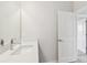 Clean bathroom with modern quartz countertop, a mirror, and an open door at 16994 Cedar Valley Cir, Clermont, FL 34711