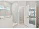 Clean bathroom showcasing a tiled shower and an open door to a carpeted bedroom at 16994 Cedar Valley Cir, Clermont, FL 34711