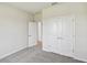 Bedroom with carpeted floors, a double door closet, and a view into a hallway at 16994 Cedar Valley Cir, Clermont, FL 34711