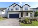 Charming two-story home with a blue garage door and stone-accented columns at 16994 Cedar Valley Cir, Clermont, FL 34711