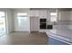 Open-concept kitchen with white cabinets, stainless appliances, and large windows at 16994 Cedar Valley Cir, Clermont, FL 34711