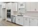 Close-up view of modern kitchen featuring white cabinets and stainless steel appliances at 16994 Cedar Valley Cir, Clermont, FL 34711