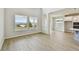 Open-concept living space with soaring ceilings, light, wood-look floors and large windows adjoins kitchen and dining at 16994 Cedar Valley Cir, Clermont, FL 34711