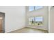 Spacious living room boasts soaring ceilings, large windows with views, and light, wood-look flooring at 16994 Cedar Valley Cir, Clermont, FL 34711