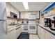 Galley kitchen with white appliances, cabinets with blue trim, and a tile backsplash at 2625 S Atlantic Ave # 24Sw, Daytona Beach, FL 32118