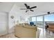 Neutral living room with dining area featuring a ceiling fan, water view, and comfortable seating at 2625 S Atlantic Ave # 24Sw, Daytona Beach, FL 32118