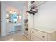 Spacious walk-in closet featuring built-in shelving, drawers, and access to a bathroom with vanity at 2625 S Atlantic Ave # 24Sw, Daytona Beach, FL 32118