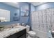 Charming bathroom with granite countertop vanity, white tub-shower combo, and serene blue walls at 9532 Black Walnut Dr, Clermont, FL 34715