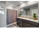 Bathroom featuring double vanity with granite countertops and a shower with a gray patterned curtain at 9532 Black Walnut Dr, Clermont, FL 34715