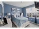 Serene bedroom featuring a queen-sized bed, soft blue walls, and abundant natural light from a window at 9532 Black Walnut Dr, Clermont, FL 34715