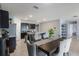Spacious dining area features sleek cabinetry, granite counters, and seating with modern upholstered chairs at 9532 Black Walnut Dr, Clermont, FL 34715