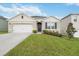 Inviting single-story home featuring a two-car garage, manicured lawn, and charming front entrance at 9532 Black Walnut Dr, Clermont, FL 34715