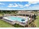 Aerial view of community pool surrounded by lounge chairs, landscaping, and a covered seating area at 9532 Black Walnut Dr, Clermont, FL 34715