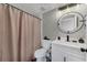 Modern bathroom featuring a round mirror and white vanity with matte black faucet at 1530 The Oaks Blvd, Kissimmee, FL 34746