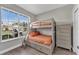 Cozy bedroom with bunk beds, wood-look flooring, a dresser, and a bright window at 1530 The Oaks Blvd, Kissimmee, FL 34746