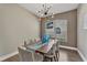 Dining room with modern chandelier, stylish decor, wood-look flooring, and a view to the exterior at 1530 The Oaks Blvd, Kissimmee, FL 34746
