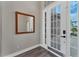 Light filled foyer showcases a mirror, wood flooring, and glass paneled front door at 1530 The Oaks Blvd, Kissimmee, FL 34746