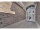 A close up front door with brick facade walls and tiled floor entry way at 1530 The Oaks Blvd, Kissimmee, FL 34746