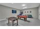 Spacious game room equipped with a pool table, foosball, and comfortable seating at 1530 The Oaks Blvd, Kissimmee, FL 34746