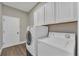 Laundry room with white cabinets, washer, and dryer at 1530 The Oaks Blvd, Kissimmee, FL 34746