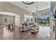 Spacious living room is filled with natural light, features wood floors, and is open to the dining and kitchen at 1530 The Oaks Blvd, Kissimmee, FL 34746