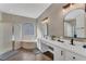 Main bathroom with double vanity, mirrors, corner tub, walk-in shower, and modern finishes at 1530 The Oaks Blvd, Kissimmee, FL 34746