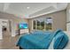 Bright main bedroom showcasing tray ceilings, wood floors, and a view of the green backyard and lanai at 1530 The Oaks Blvd, Kissimmee, FL 34746