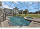 Inviting screened-in pool and spa with lush landscaping and a beautiful backyard at 1530 The Oaks Blvd, Kissimmee, FL 34746