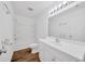 Bathroom features a tub with white tile surround, an all-white vanity, and modern fixtures at 2425 Anderson, Mulberry, FL 33860