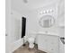 Bright bathroom featuring a shower-tub combo, a round mirror, and a modern vanity with storage at 2425 Anderson, Mulberry, FL 33860