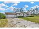 Charming single-story home with an attached garage, gravel driveway, and beautiful lawn at 2425 Anderson, Mulberry, FL 33860