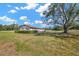 Single-story home with a well-manicured lawn and a large shade tree on the side at 2425 Anderson, Mulberry, FL 33860