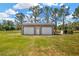 Two-car garage with roll-up doors surrounded by a well-maintained green lawn at 2425 Anderson, Mulberry, FL 33860