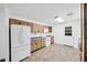 Well-equipped kitchen with white appliances, wood cabinets and vinyl floors at 2425 Anderson, Mulberry, FL 33860
