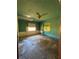 Green bedroom with a ceiling fan, stained glass window, and visible signs of wear and tear; renovation needed at 2610 Tennessee Rd, Lakeland, FL 33815