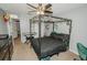 Nicely appointed bedroom featuring a black four-poster bed adorned with decorative vines and ceiling fan at 1808 Ashton E Dr, St Cloud, FL 34771