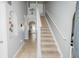 Bright hallway featuring staircase, tiled floor, and 'This is Us' sign at 1808 Ashton E Dr, St Cloud, FL 34771